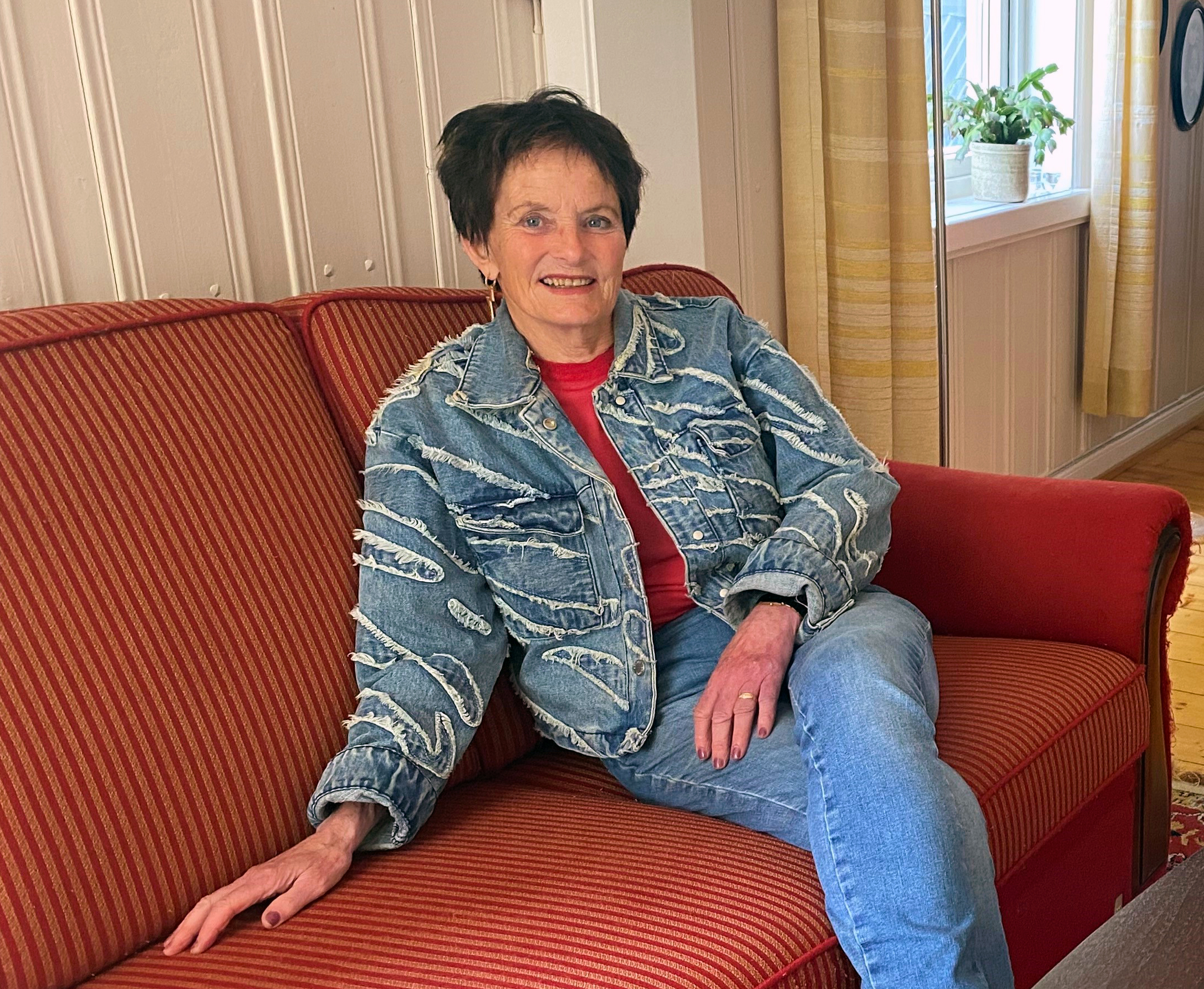 Bildet viser Kjærsti Tullemor Floden hjemme i sofaen på gården FLoden.