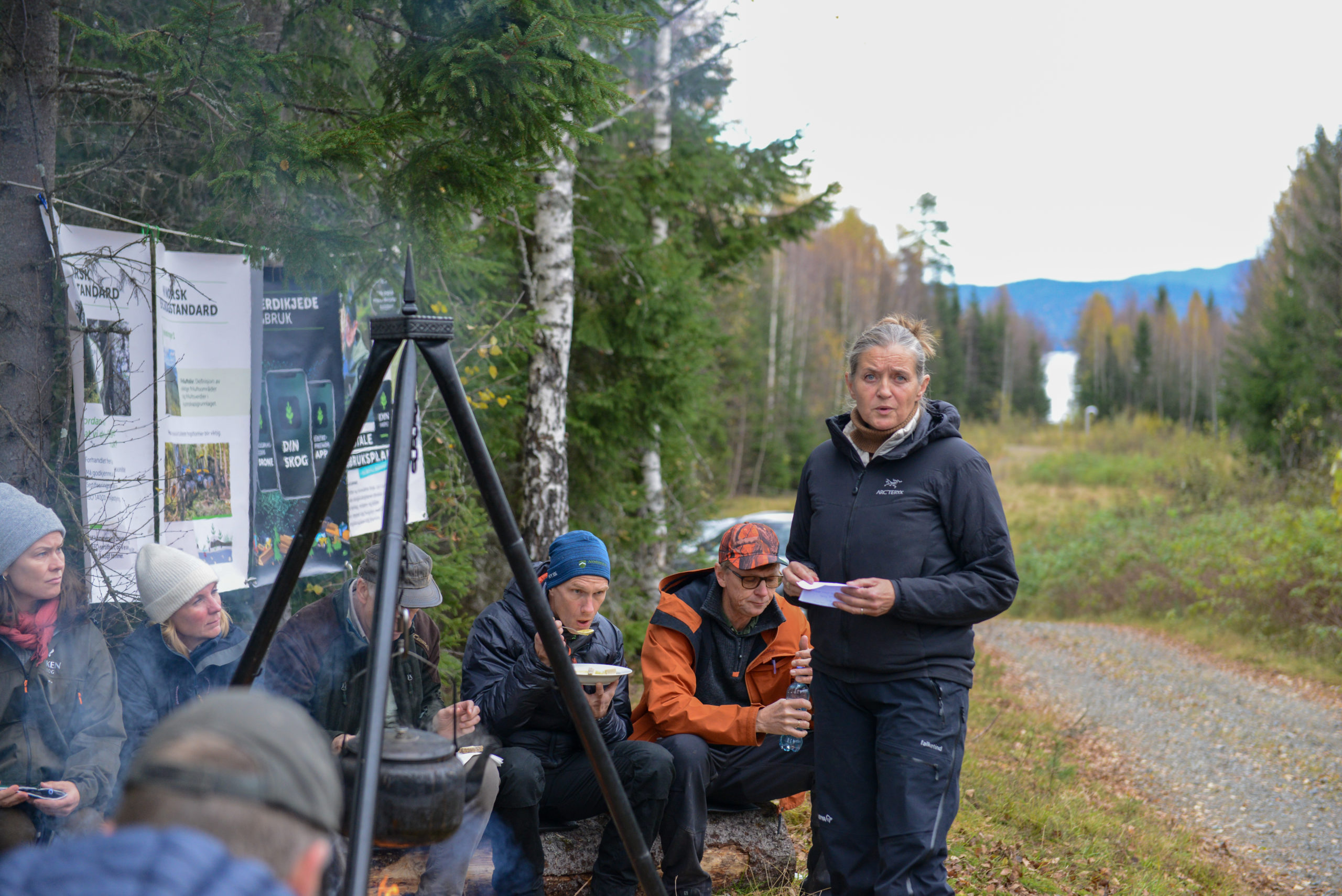 Heidi Hemstad snakker foran en gruppe rundt en bålpanne.