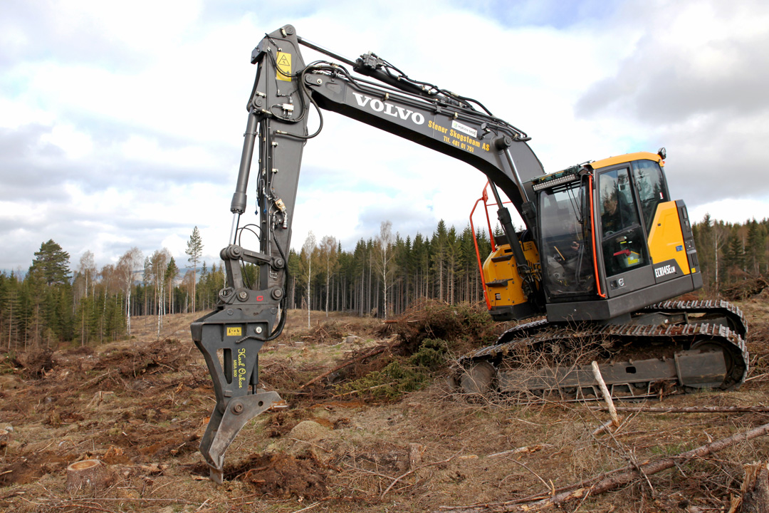 Gravemaskin bearbeider skogsjorda flekkvis på et hogd område.