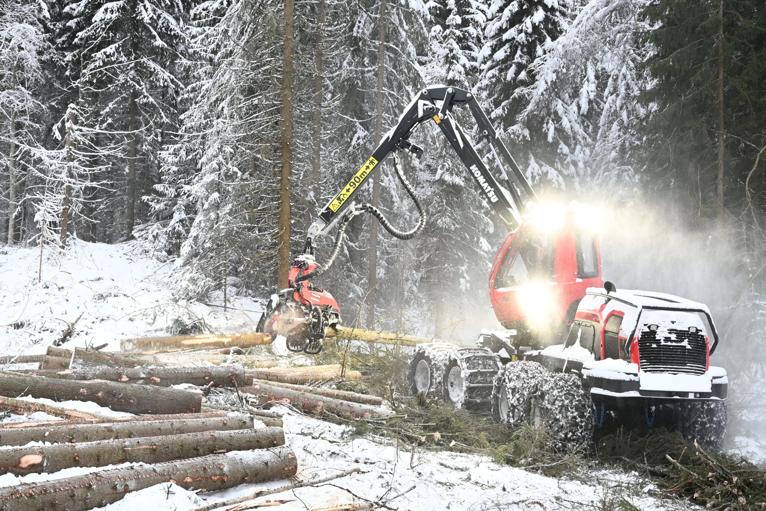 Hogstmaskin i vinterskog.